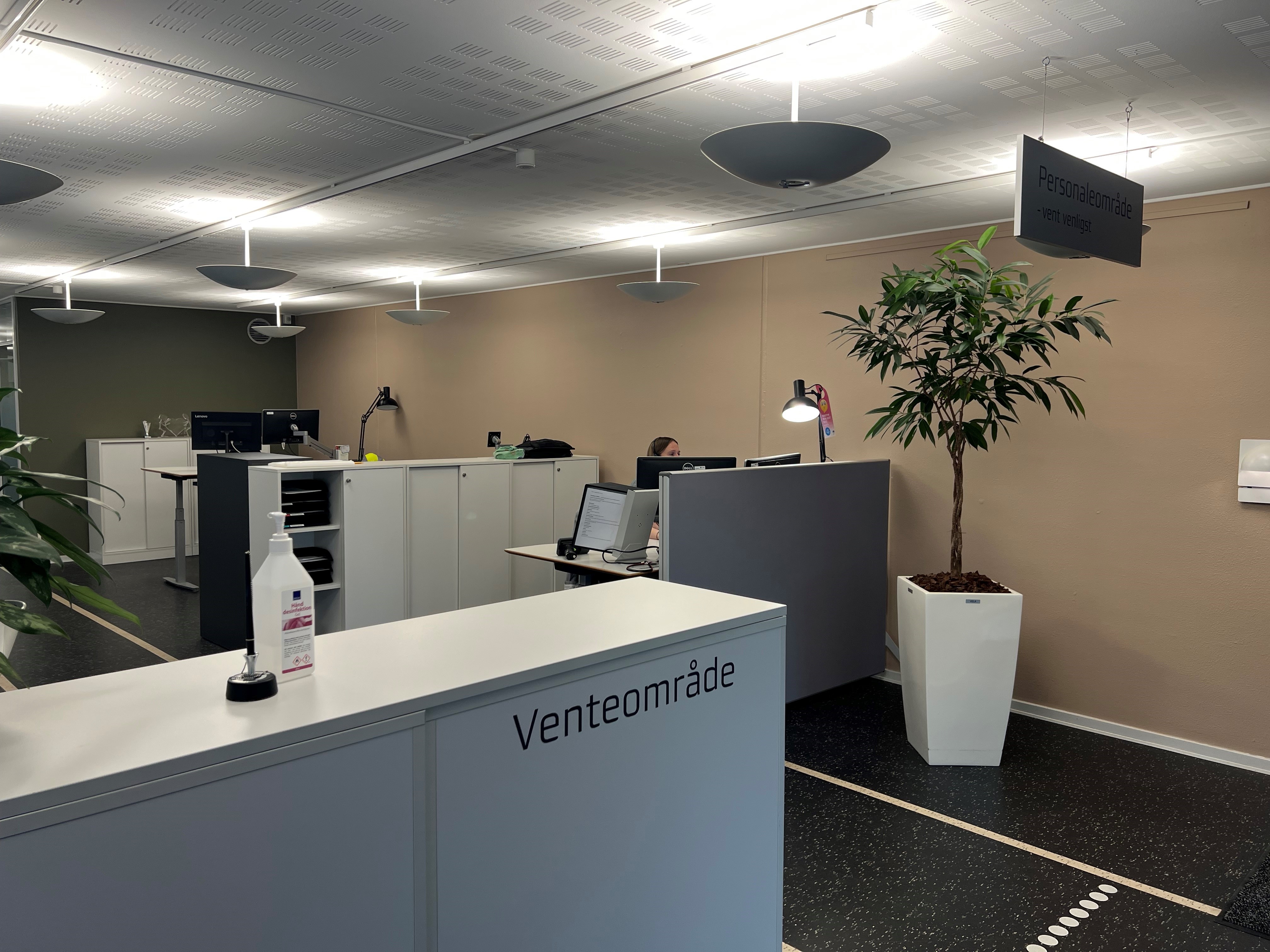 Receptionen hos Center for Hjælpemidler, hvor en medarbejder tager imod de besøgende. 